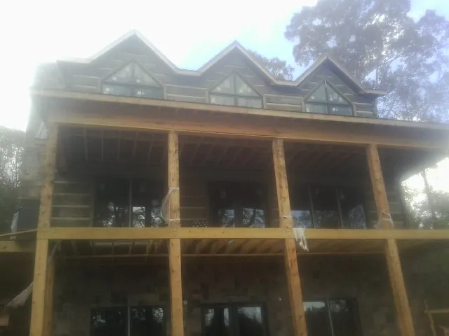 Dormers and porch framing on a large log home under construction — Roof Coating work by our crew in Storrs Mansfield