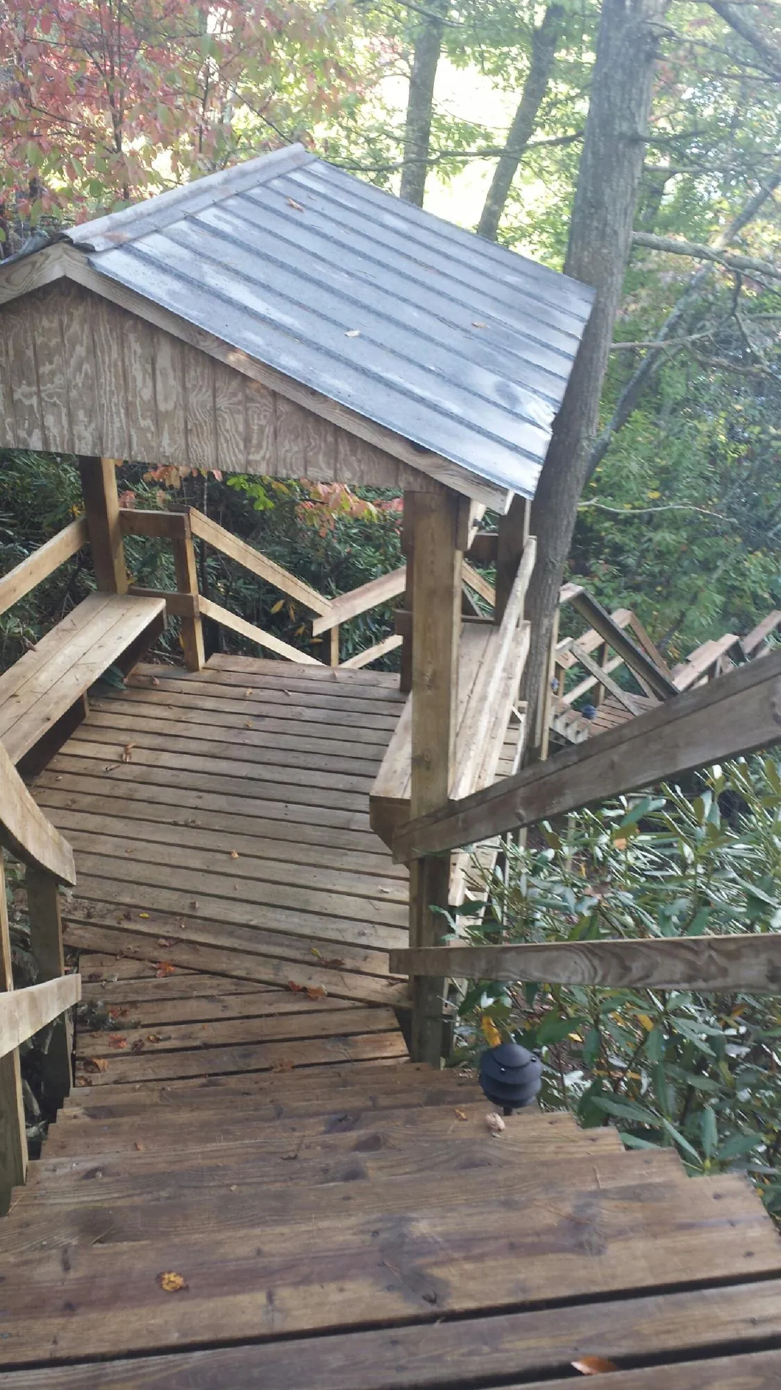 Metal roofed shelter over wooden steps on a wooded walkway — Skylight Repair & Installation work by our crew in Storrs Mansfield