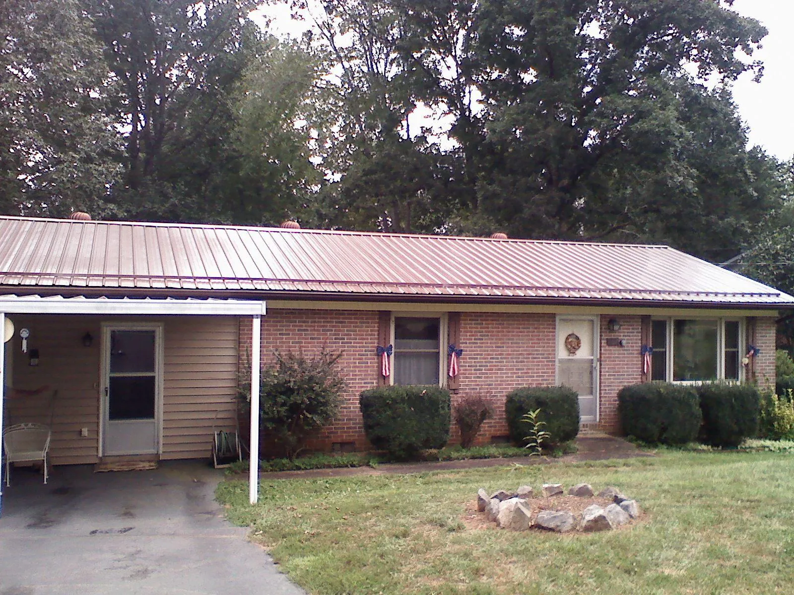 Bronze metal roof and carport on a brick ranch home — Roof Repair work by our crew in Storrs Mansfield